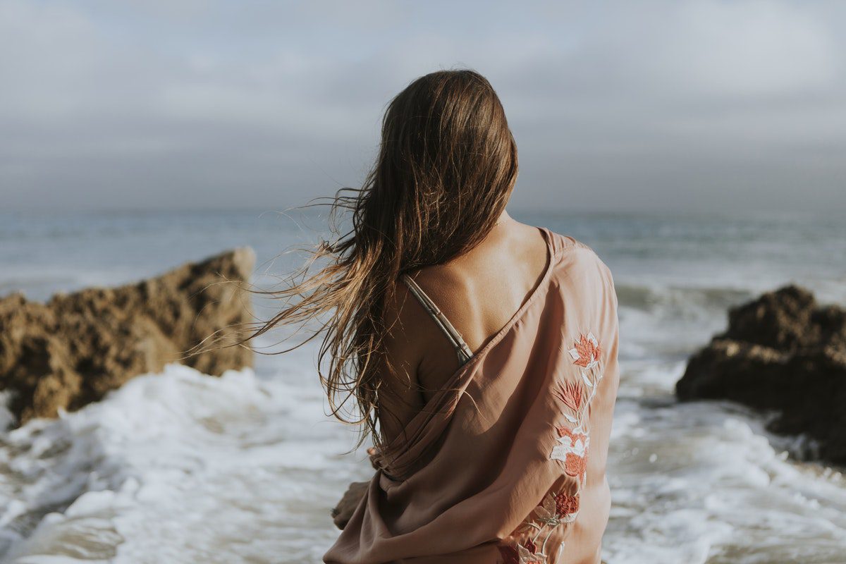 Back shot of woman in front of the beach