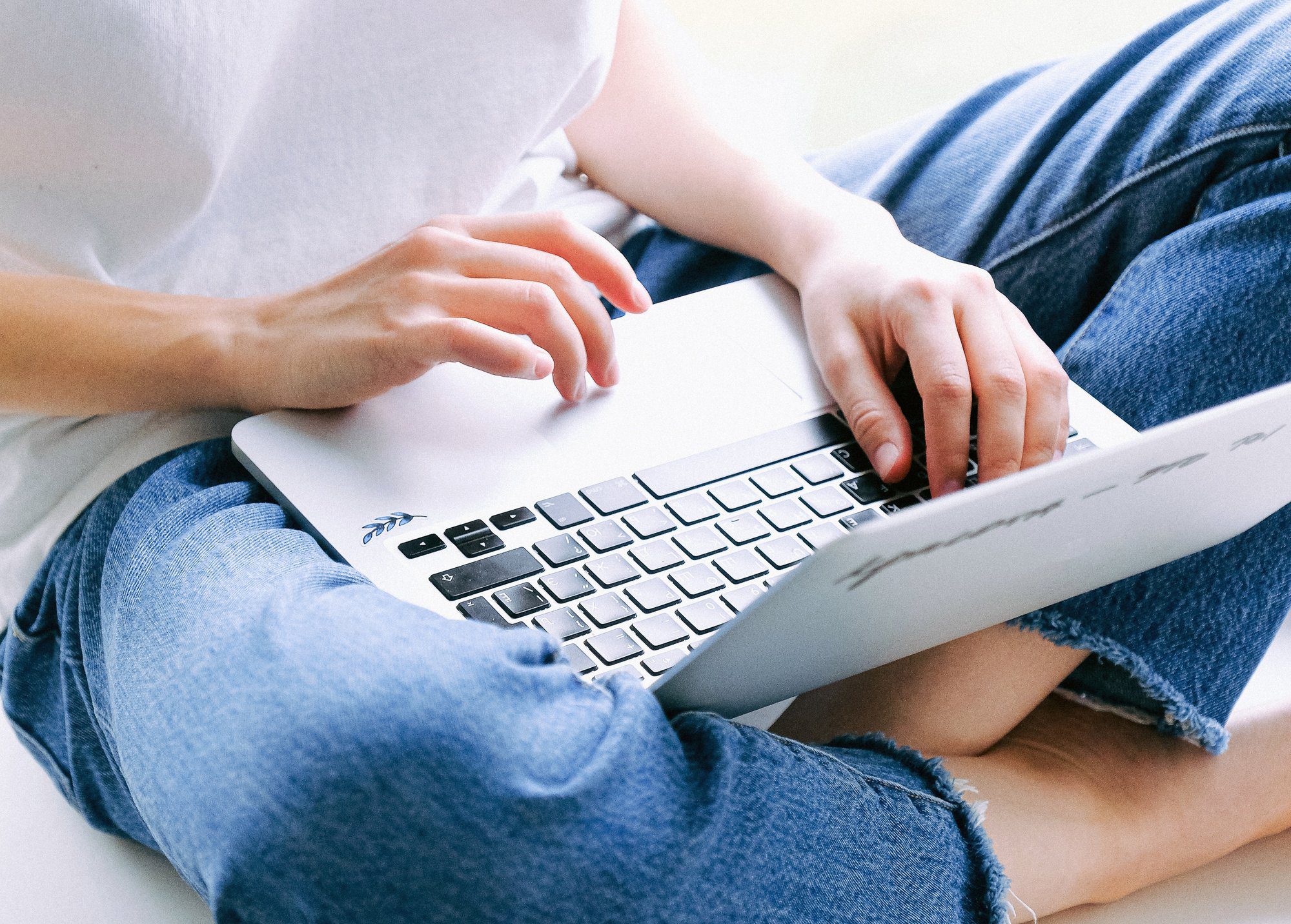 close up of person in blue jeans using laptop