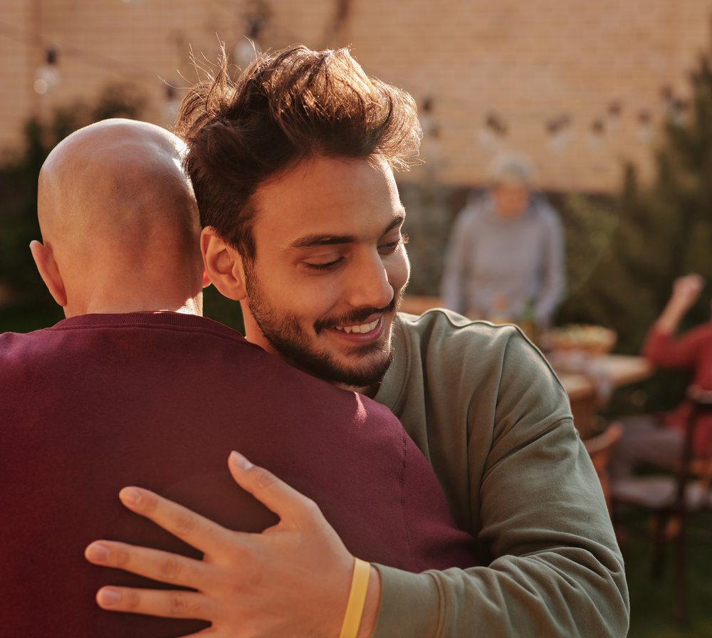 man in long sleeve shirt hugging a friend