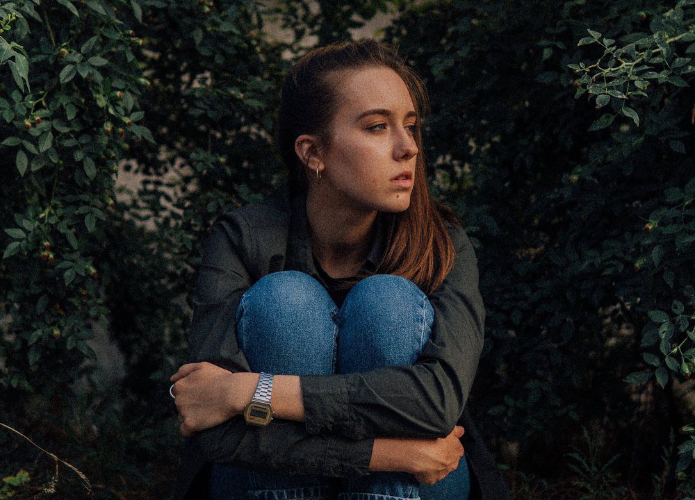 young woman looking to the side with a sad face