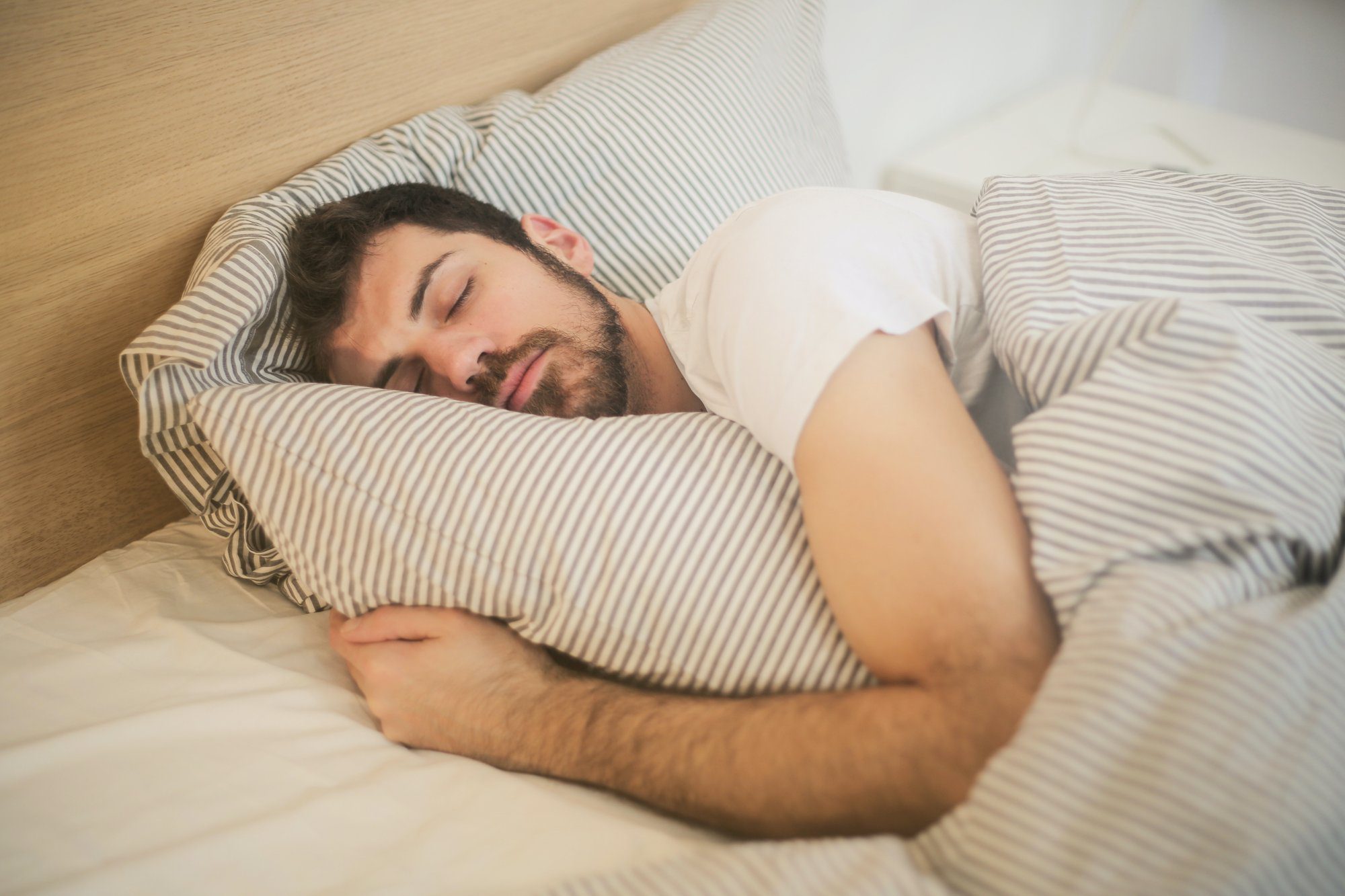 man sleeping hugging a pillow