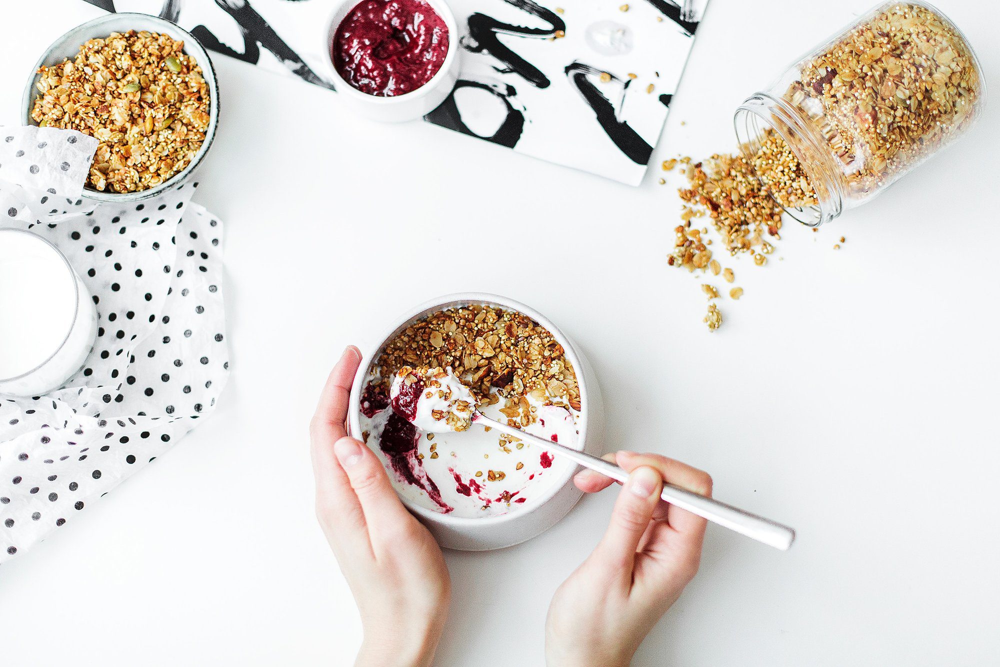 cereal, milk and strawberry jam on white ceramic bowl