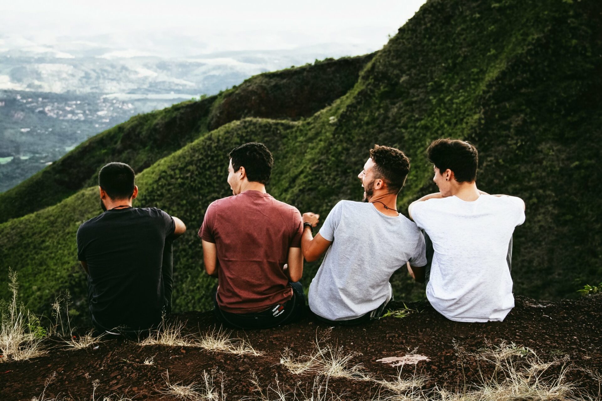 a group of men sitting on a mountain