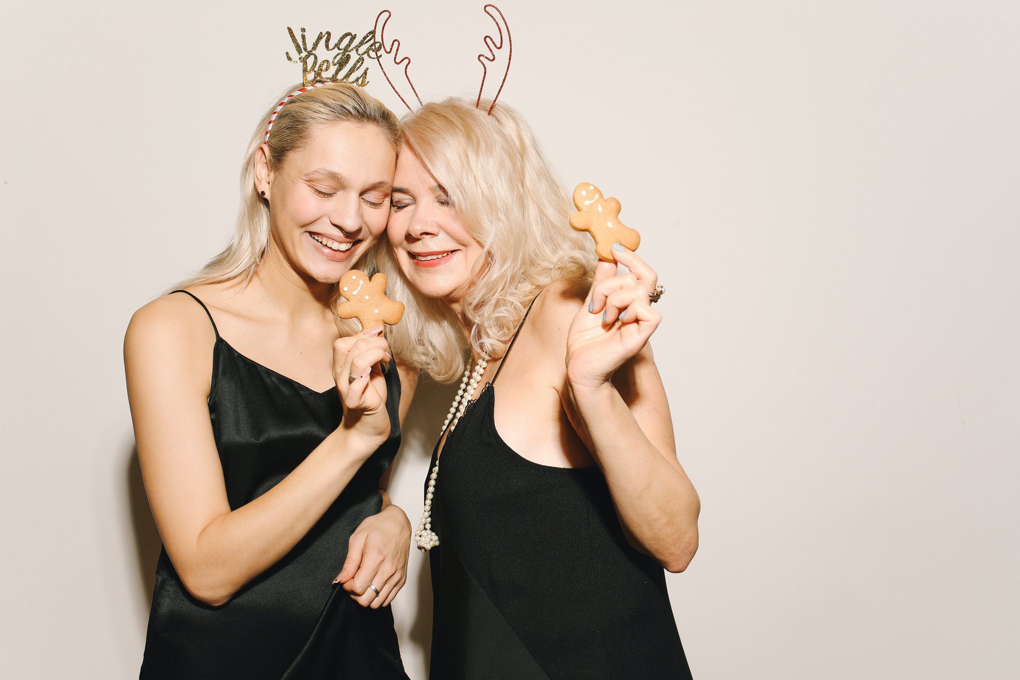 portrait of a happy mother and daughter holding gingerbread cookies